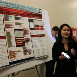 A student discusses her research poster